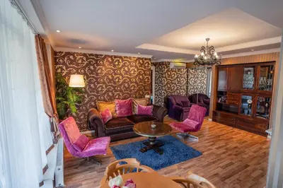 a living room with purple chairs and a table at Alpetri Apartments in Kaunas