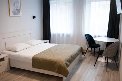a bedroom with a bed and a table and chairs at Dzūkija Hotel in Alytus