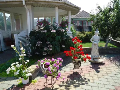 a garden with a statue and flowers on a patio at Guest House Linas in Alytus
