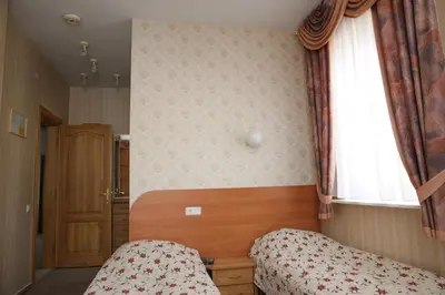 a small bedroom with two beds and a window at Guest House Linas in Alytus
