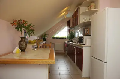 a kitchen with a white refrigerator and a table at Guest House Linas in Alytus