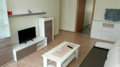 a living room with a television and a white table at Gražinos apartamentai in Panevėžys