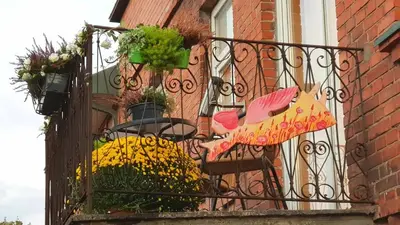 a wrought iron fence with flowers on a balcony at Old Town Apartments in Alytus