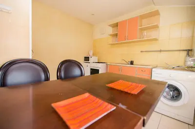 a kitchen with a table and a washing machine at Old Town Apartments in Alytus