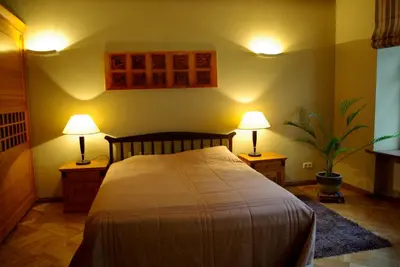 a bedroom with a bed and two lamps on tables at Pilies Apartments in Vilnius