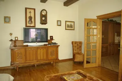 a living room with a television on a wooden entertainment center at Pilies Apartments in Vilnius