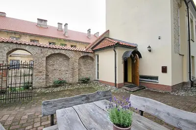 a wooden bench in the courtyard of a building at Pilies Apartments in Vilnius