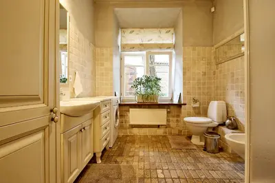 a bathroom with a sink and a toilet and a window at Pilies Apartments in Vilnius
