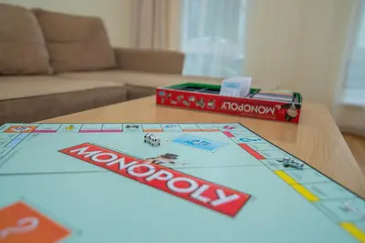 a table with a monopoly board game on it at Guest House Milda in Druskininkai