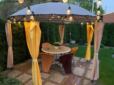 a gazebo with a table and chairs under it at Broliu Vila in Druskininkai