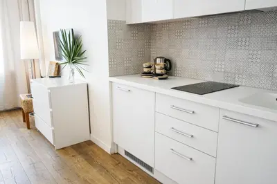 a kitchen with white cabinets and a sink at Guest House Senasis Pastas in Druskininkai