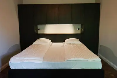 a bedroom with a large bed with a black headboard at Guest House Senasis Pastas in Druskininkai
