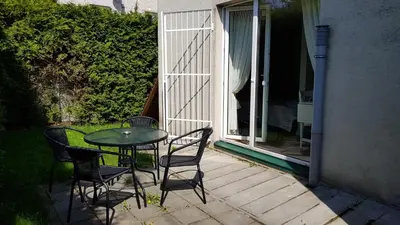 a patio with a table and chairs on a porch at Cozy Garden Free parking in Vilnius