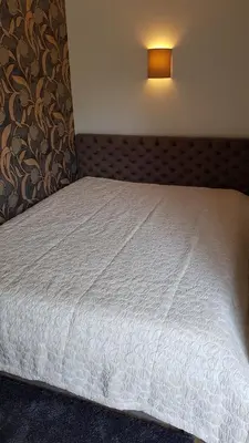 a bedroom with a white bed with a light on it at Cozy Garden Free parking in Vilnius