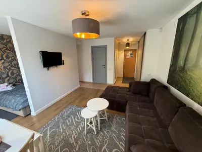 a living room with a couch and a table at Cozy Garden Free parking in Vilnius