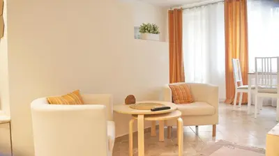 a living room with a table and two chairs at Apartamentai Druskininkuose in Druskininkai