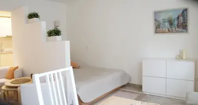 a small bedroom with a bed and a staircase at Apartamentai Druskininkuose in Druskininkai