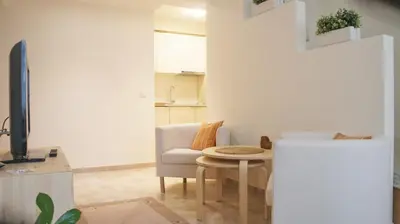 a living room with a table and a refrigerator at Apartamentai Druskininkuose in Druskininkai