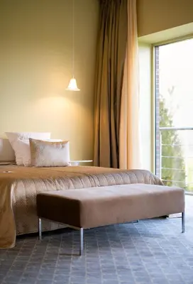 a bed in a room with a large window at Harmony Park Hotel & SPA in Prienai