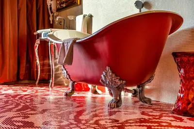 a red bath tub sitting on the floor in a bathroom at Harmony Park Hotel & SPA in Prienai