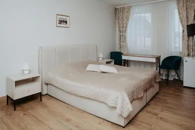 a bedroom with a bed and a table and chairs at Verslo Klasė-easy to stay in Panevėžys