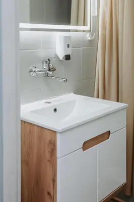 a bathroom with a white sink and a mirror at Verslo Klasė-easy to stay in Panevėžys