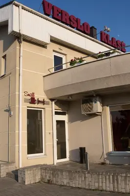 a restaurant with a sign on top of a building at Verslo Klasė-easy to stay in Panevėžys