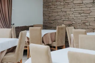 a room with tables and chairs and a brick wall at Verslo Klasė-easy to stay in Panevėžys