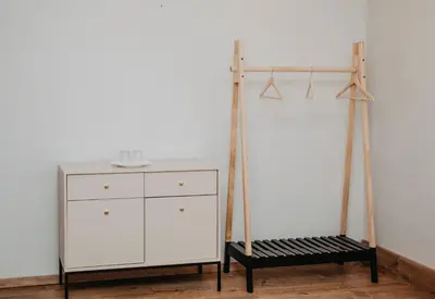 a white dresser next to a white cabinet and a shelf at Verslo Klasė-easy to stay in Panevėžys