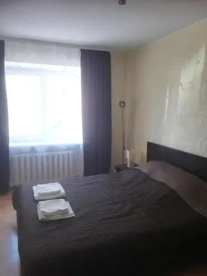 a bedroom with a bed with two towels on it at Butas Vilniaus alėjoje in Druskininkai