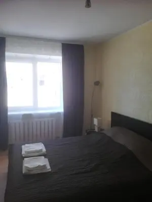 a bedroom with a bed with two towels on it at Butas Vilniaus alėjoje in Druskininkai