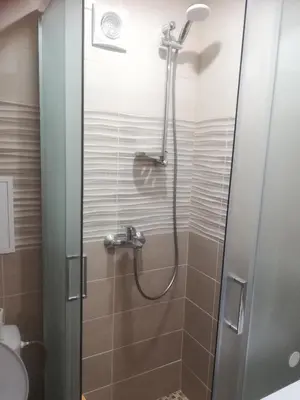 a shower with a glass door in a bathroom at Butas Vilniaus alėjoje in Druskininkai