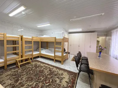 a room with bunk beds and a table and chairs at Nakvisa in Zarasai