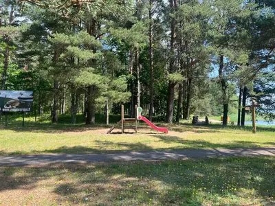 a playground with a red slide in a park at Salako svečių namai in Salakas