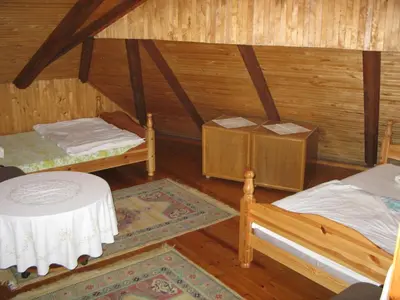 a room with two beds and a table in it at Salako svečių namai in Salakas
