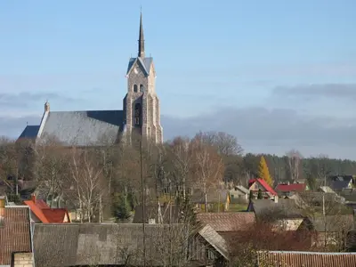 a church with a steeple on top of a town at Salako svečių namai in Salakas