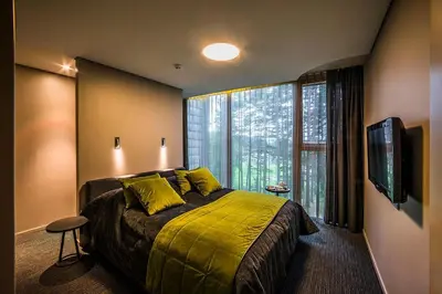 a bedroom with a large bed and a large window at TonyResort in Trakai
