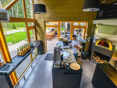 a man standing in front of a kitchen with a oven at TonyResort in Trakai