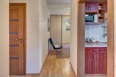 a kitchen with a door and a chair in a room at Vidos apartamentai 2 in Vilnius