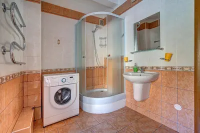 a bathroom with a washing machine and a sink at Vidos apartamentai 2 in Vilnius