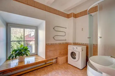 a bathroom with a washing machine and a window at Vidos apartamentai 2 in Vilnius