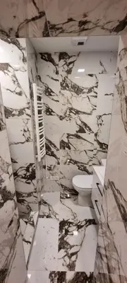 a marble bathroom with a toilet and a sink at Kaimo turizmo sodyba 