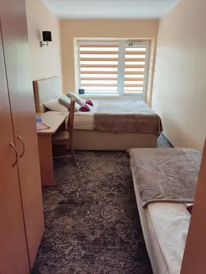 a room with two beds and a table and a window at Kaimo turizmo sodyba 