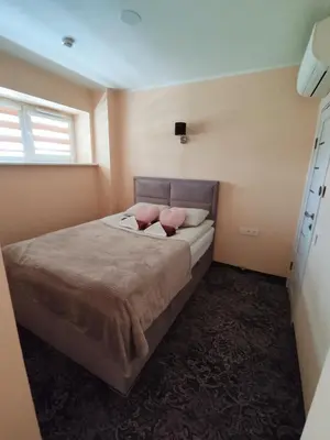 a bedroom with a bed with two pink pillows at Kaimo turizmo sodyba 