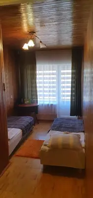 a bedroom with two beds and a window at Kaimo turizmo sodyba 