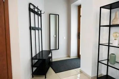 a hallway with a mirror and a black shelf at Kaunas Old Town Apartment in Kaunas