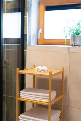 a bathroom with a wooden shelf with towels at Kaunas Old Town Apartment in Kaunas