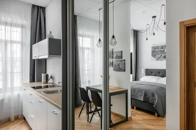 a kitchen and a bedroom with a bed and a table at Piano Apartments in Kaunas