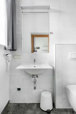 a white bathroom with a sink and a toilet at Piano Apartments in Kaunas