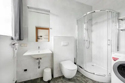 a bathroom with a sink and a shower and a toilet at Piano Apartments in Kaunas